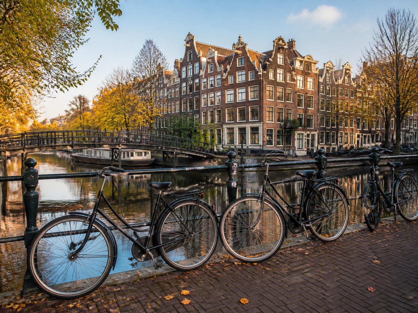 Autumn afternoon along a Dutch canal with gabled houses and bicycles
